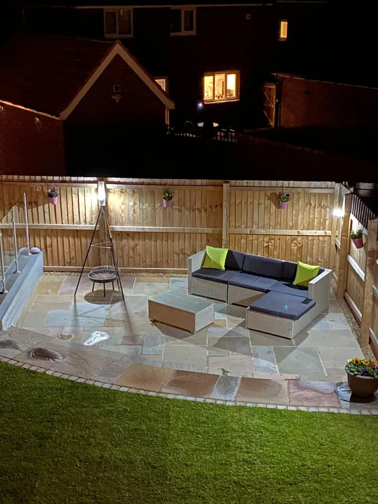 Indian stone patio with outdoor seating, lit for the evening